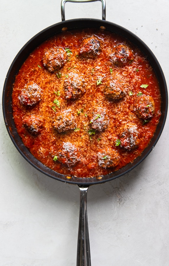 A close up of meatballs with red sauce in a skillet
