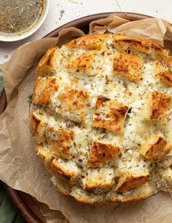 cheesy pull apart bread on serving dip with dipping oil