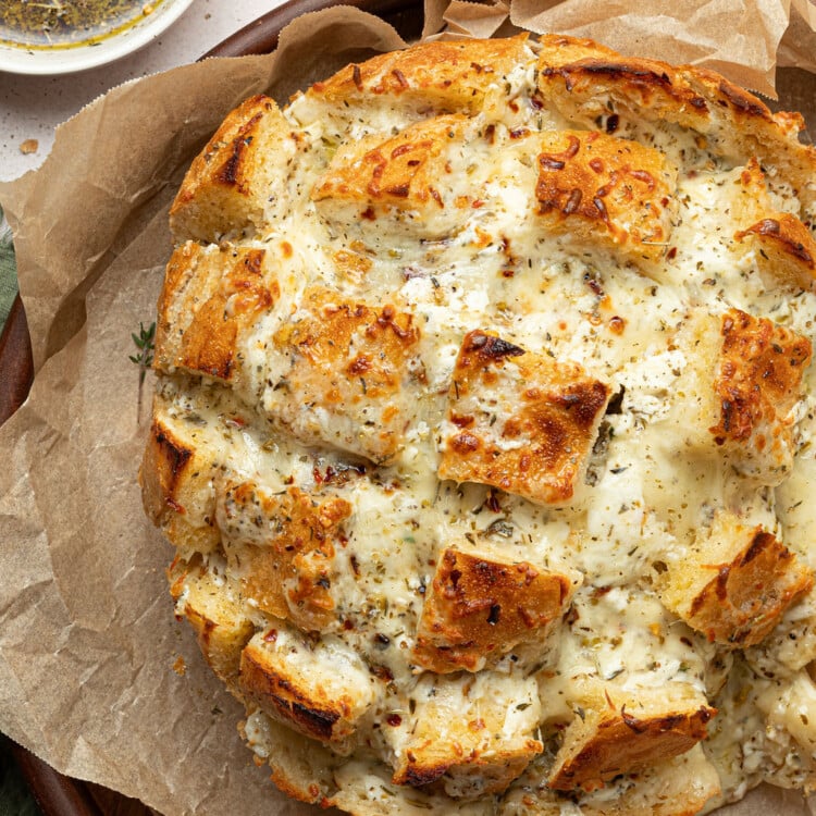 cheesy pull apart bread on serving dip with dipping oil