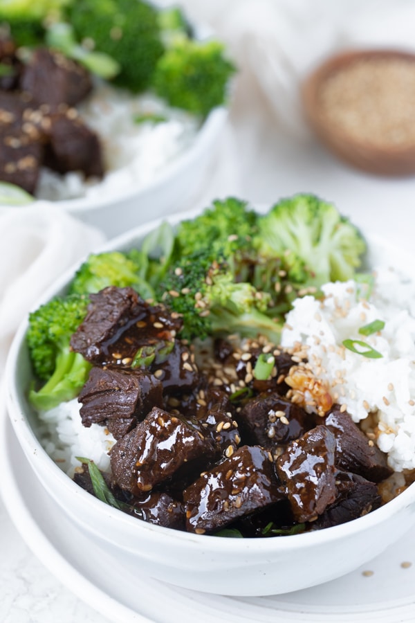 steak bites in a white bowl with rice and broccoli