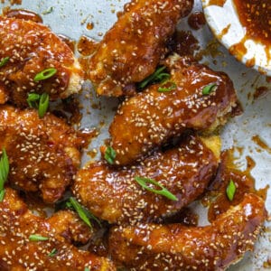 sesame chicken on a sheet pan with sesame seeds and green onions on top