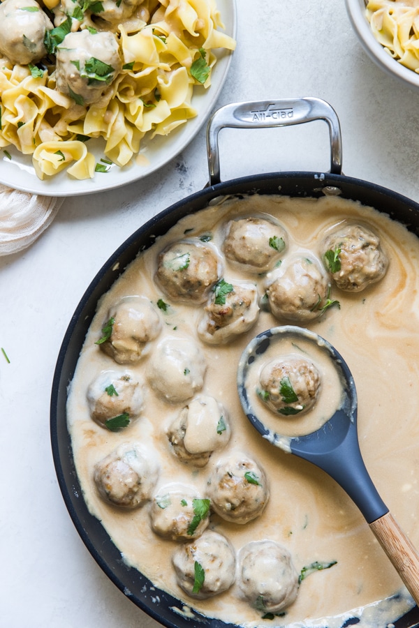 Swedish Meatballs in gravy in a cast iron skillet tossed with wide egg noodles