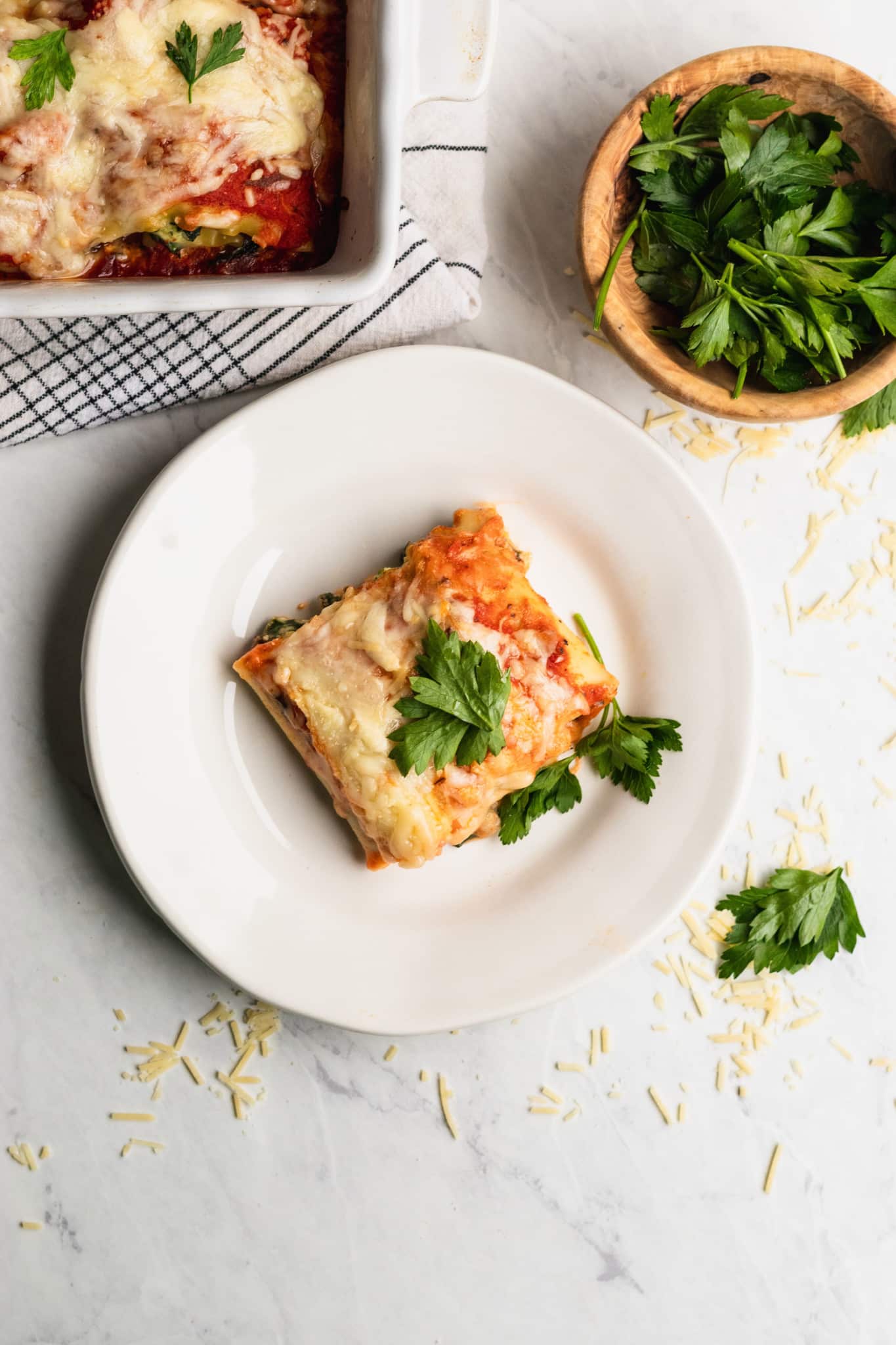 lasagna roll up on a white plate garnished with fresh parsley