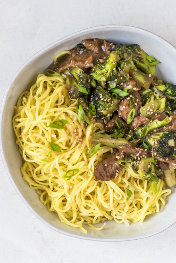 beef and broccoli with noodles in a white bowl