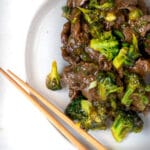 beef and broccoli with noodles in a white bowl