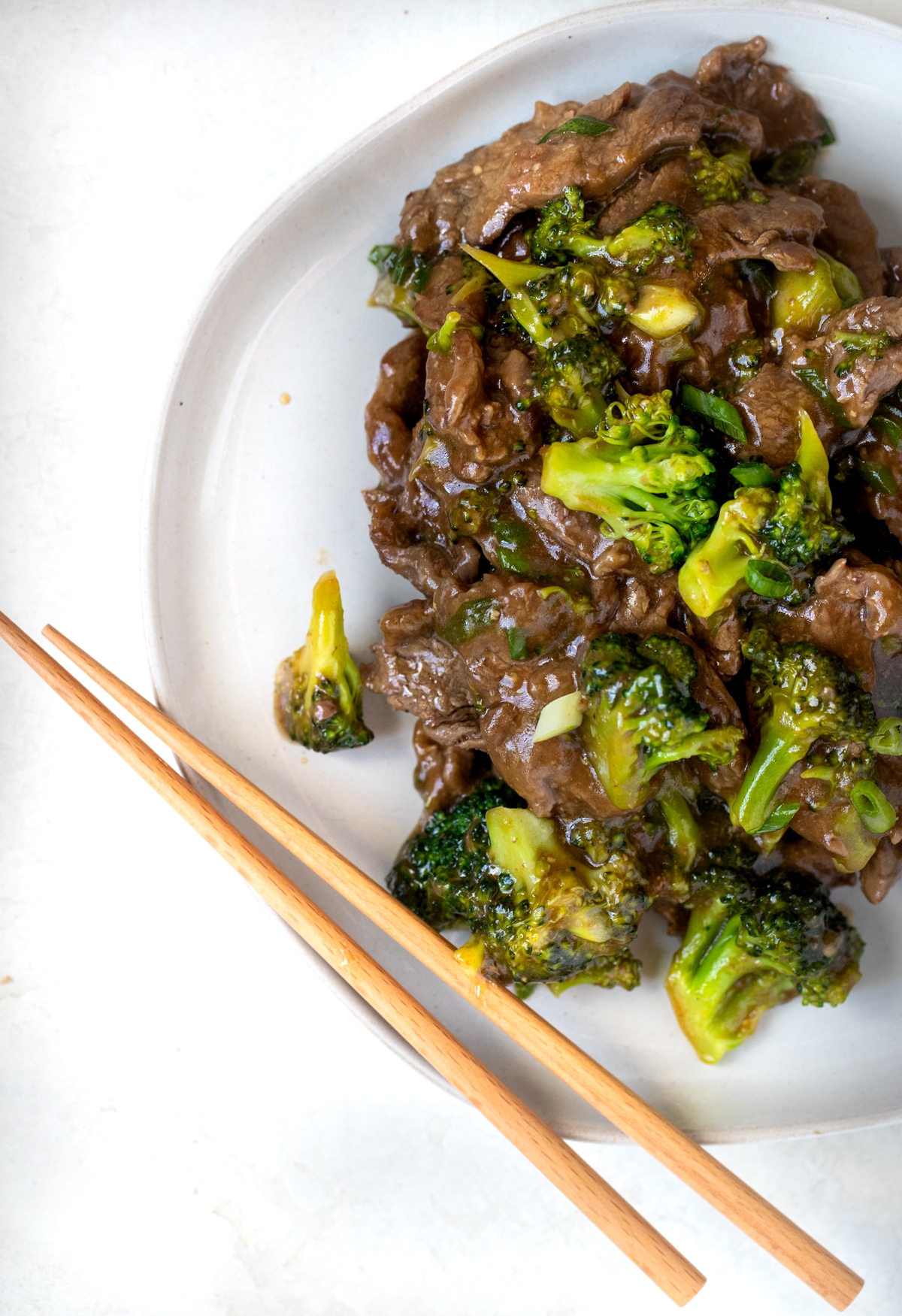 beef and broccoli with noodles in a white bowl
