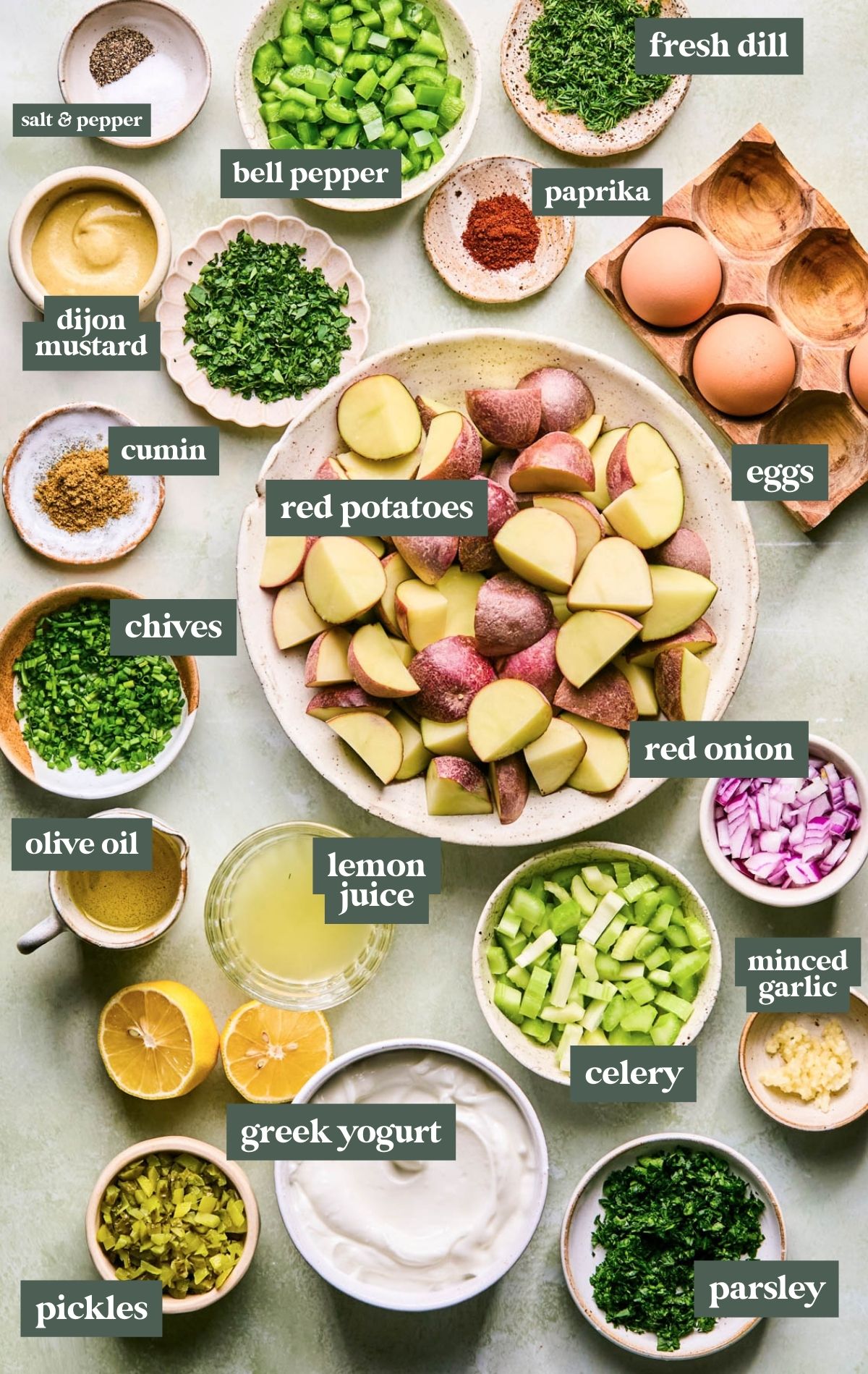 Bowls of various sizes containing ingredients to make a lightened up potato salad.