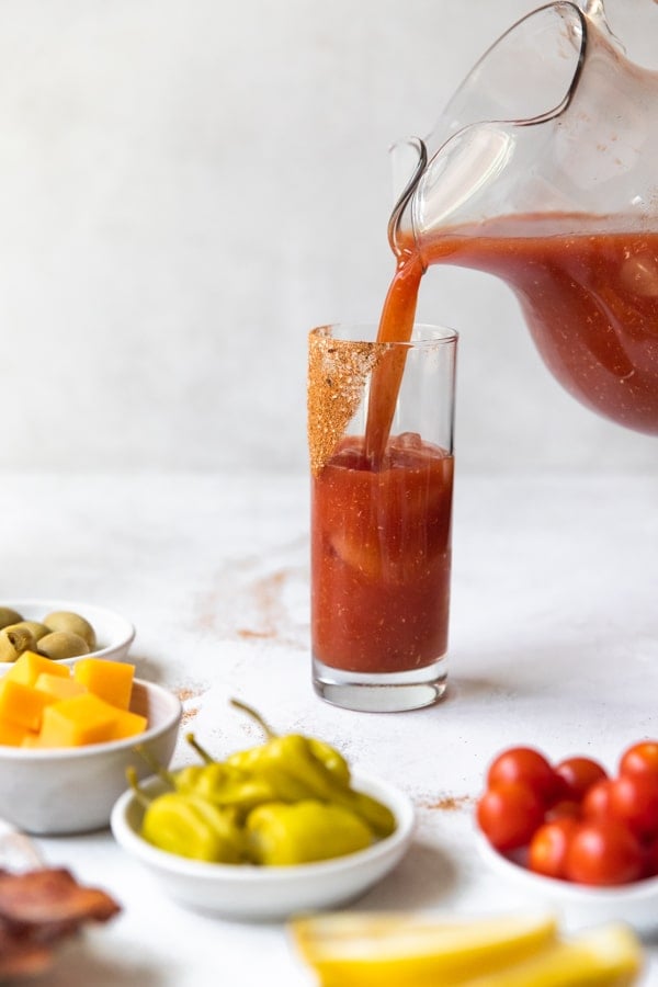 spicy bloody mary mix being poured into a glass