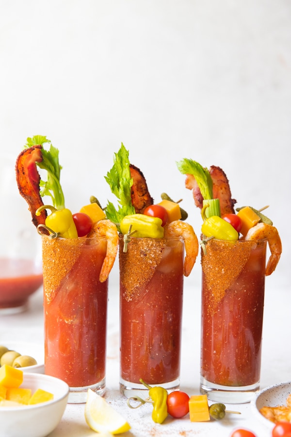 bloody marys in highball glasses with celery and bacon