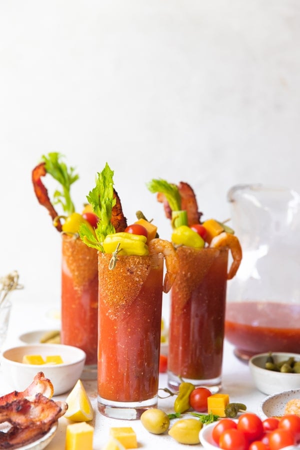 bloody marys in highball glasses with celery and bacon