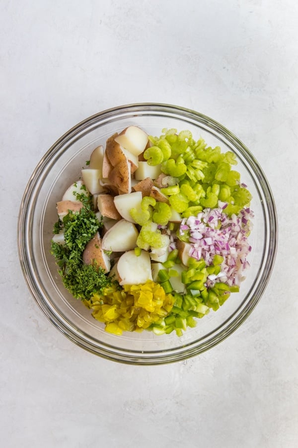 potato salad ingredients in a large glass bowl