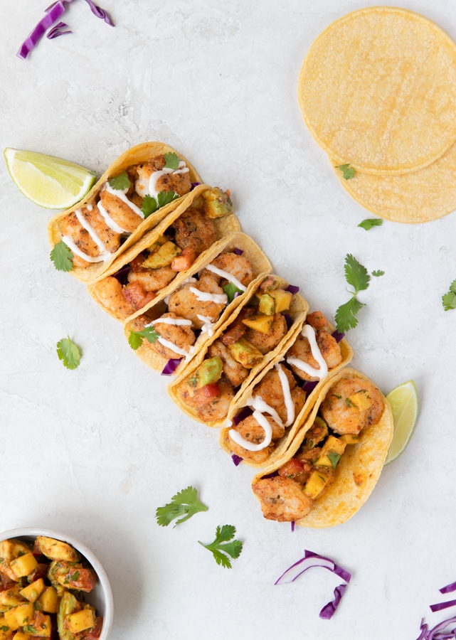 spicy shrimp tacos on a white board