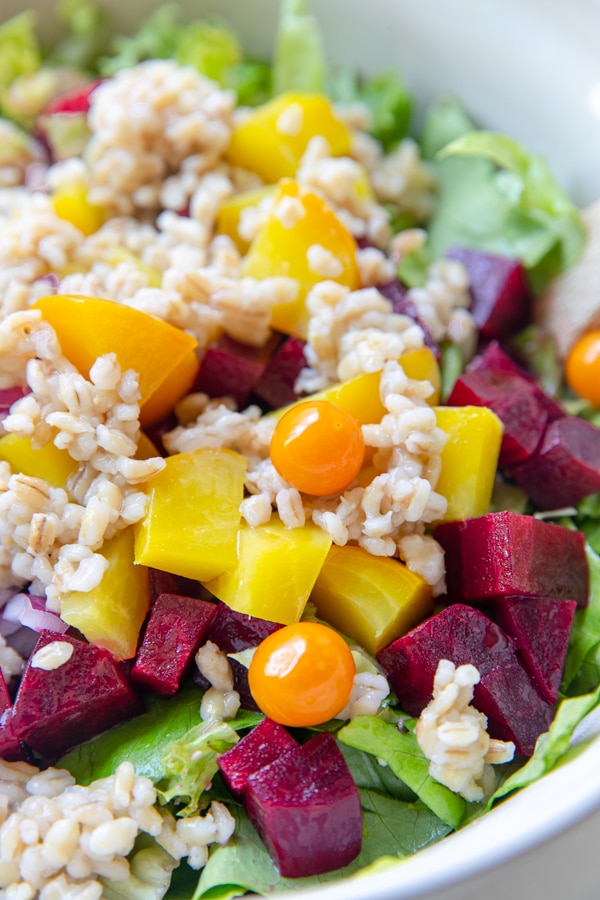 red and yellow beets with barley and lettuce in a bowl