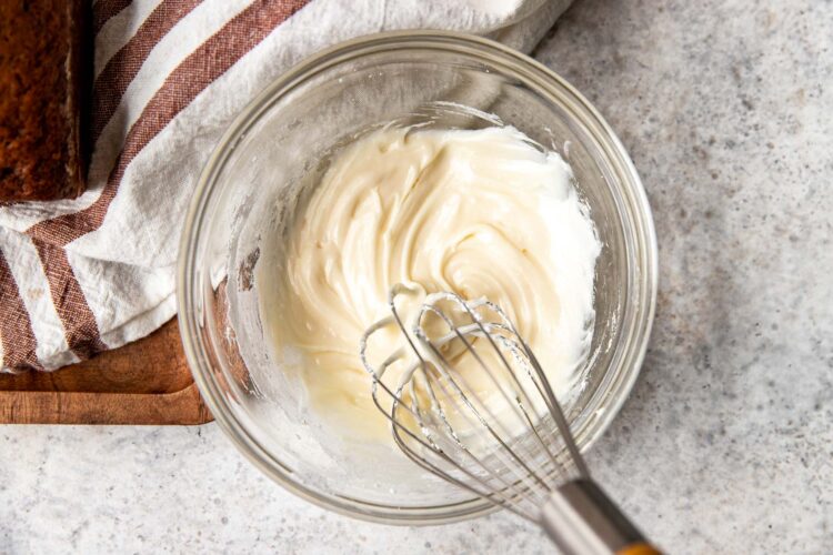 frosting being whisked together in a glass bowl.