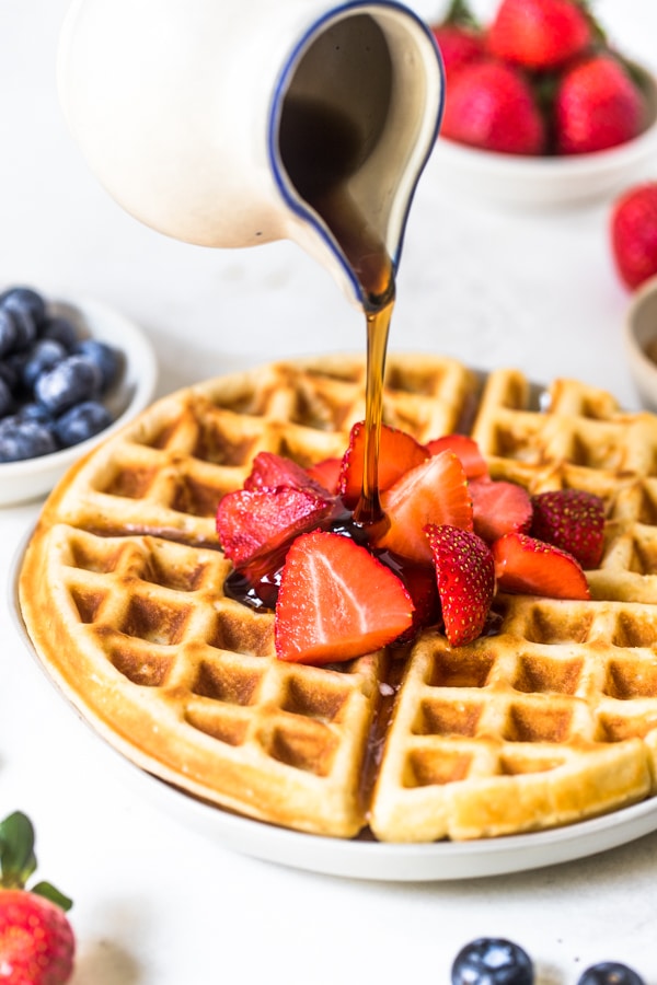 syrup being poured on buttermilk waffles