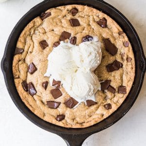 a cookie in a cast iron skillet with ice cream on top