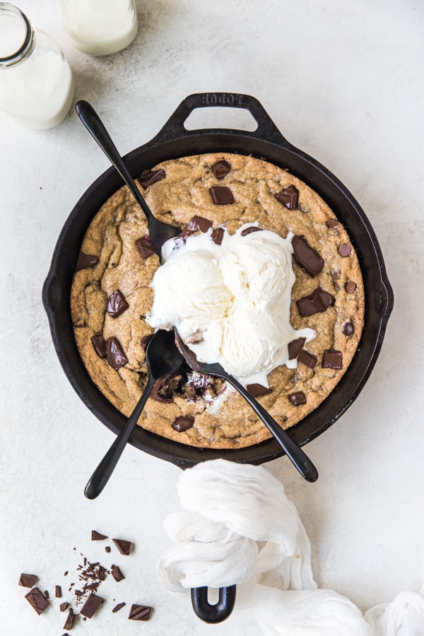 a cookie in a cast iron skillet with ice cream on top