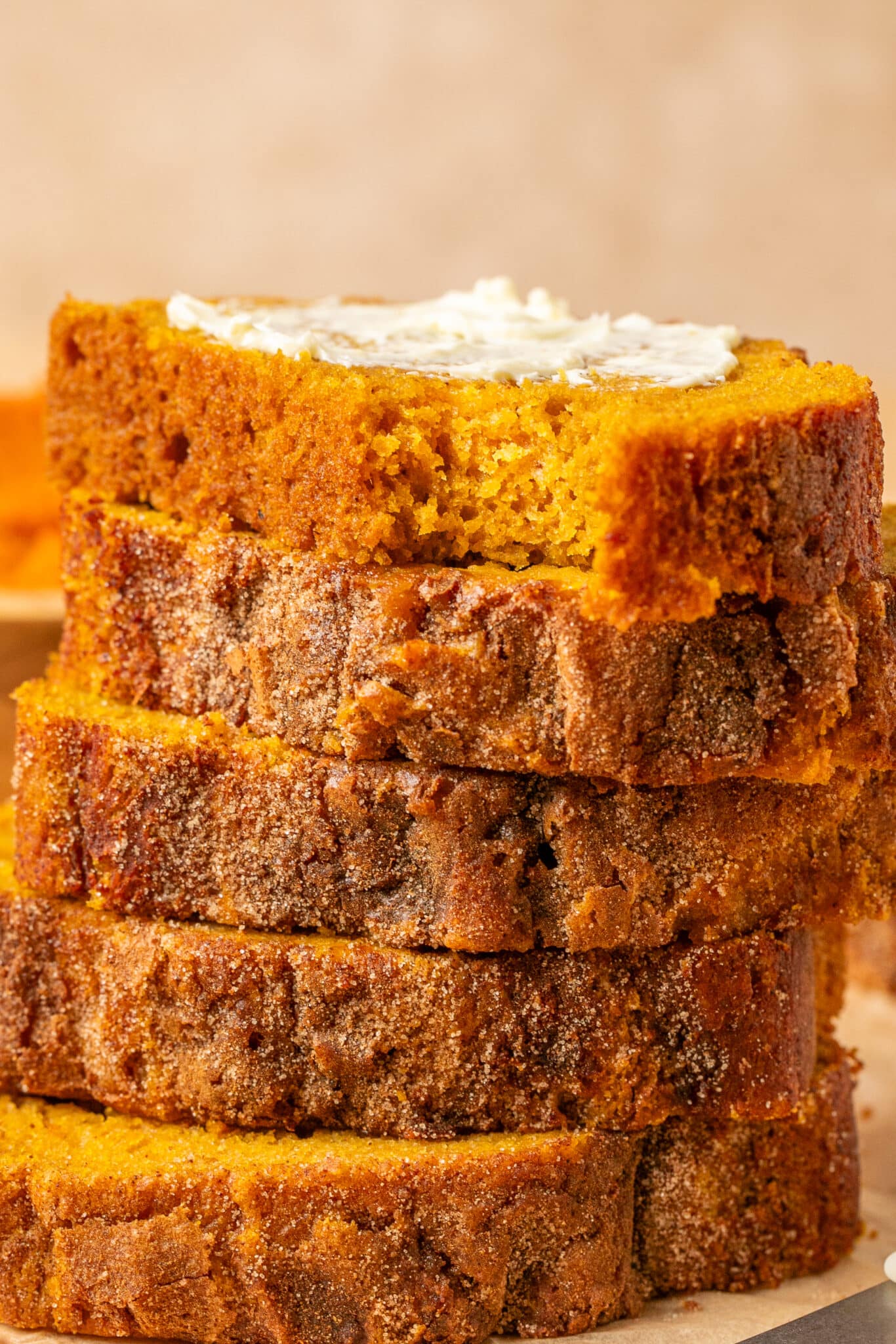 up close image of pumpkin bread slices stacked on top of each other. 