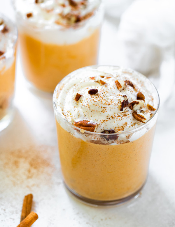 pumpkin mousse in a glass topped with whipped cream and pecans