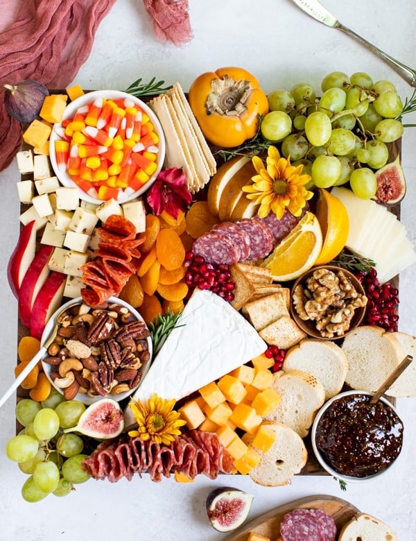 fruits, meats and cheese on a cutting board