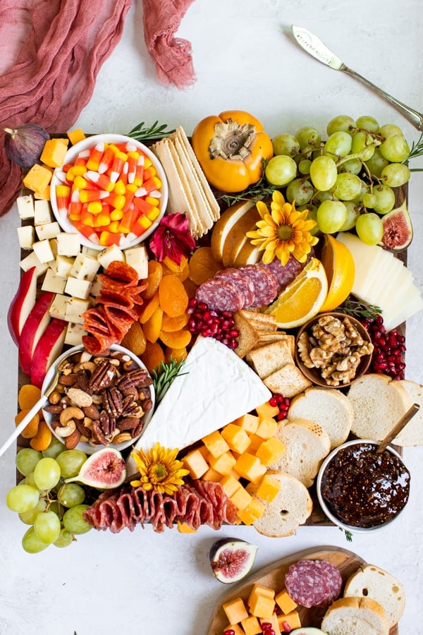 fruits, meats and cheese on a cutting board