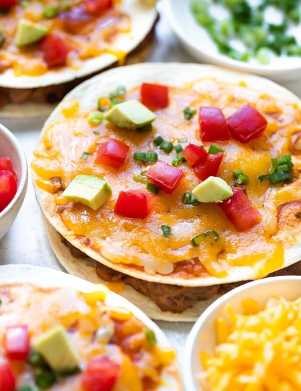 mexican pizza topped with tomatoes and avocado