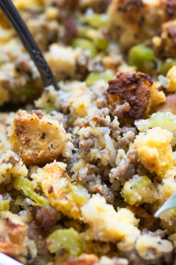 cornbread stuffing made with sausage and herbs in a white casserole dish