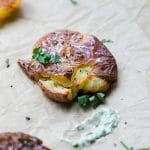 smashed baby potatoes on parchment paper