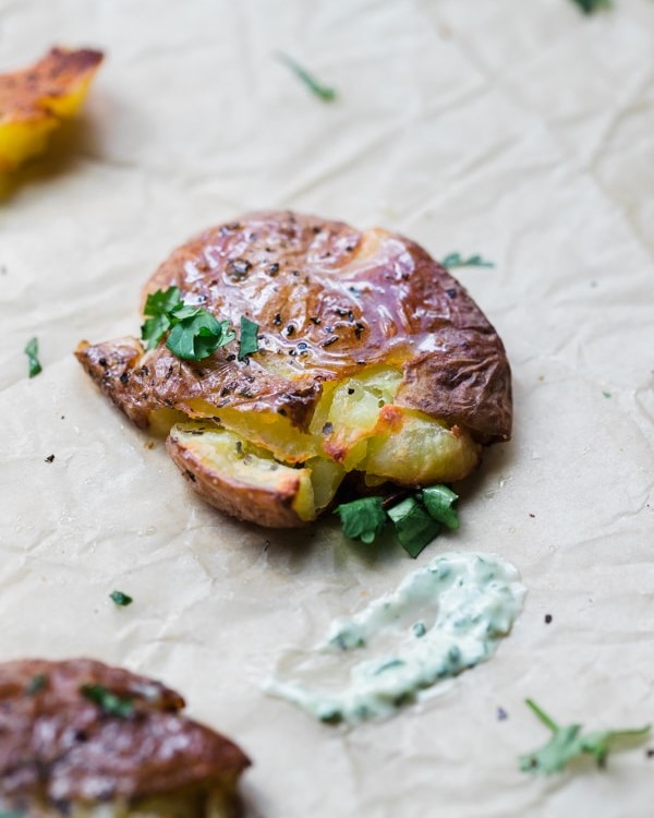 smashed baby potatoes on parchment paper