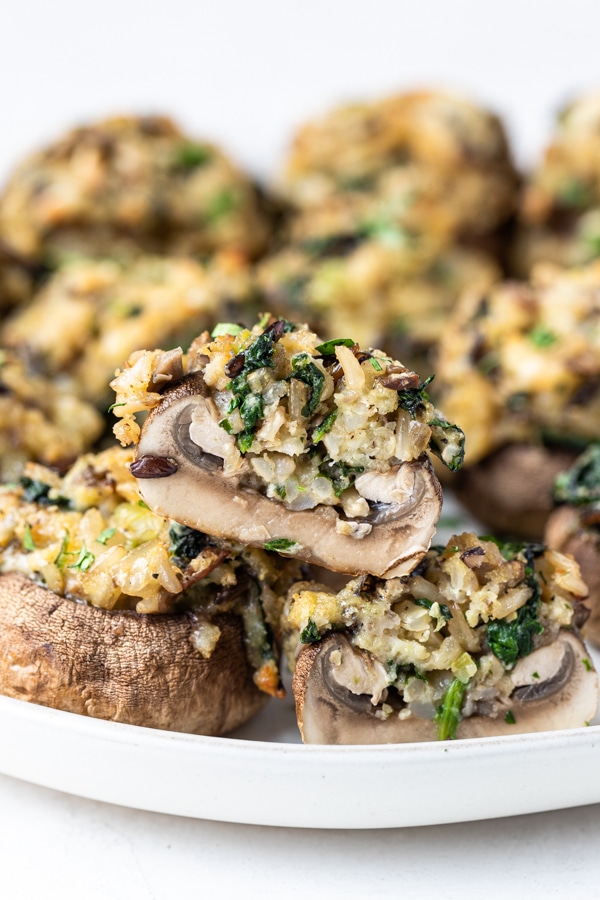 a stuffed mushroom cut in half on a white plate