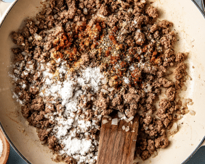 Adding the spices and cornstarch to the cooked ground beef mixture.