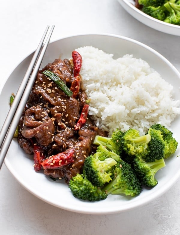 Mongolian beef with rice and broccoli in a white bowl