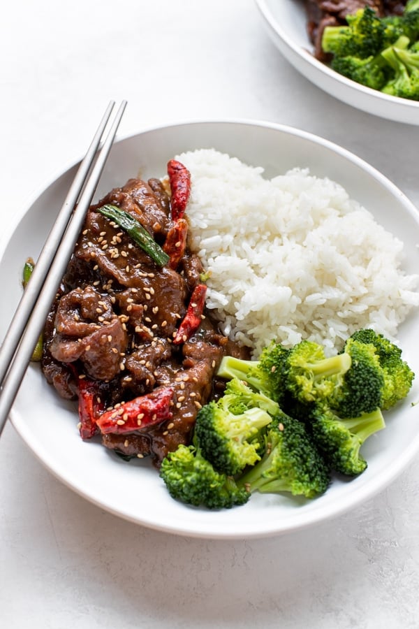 Mongolian beef with rice and broccoli in a white bowl