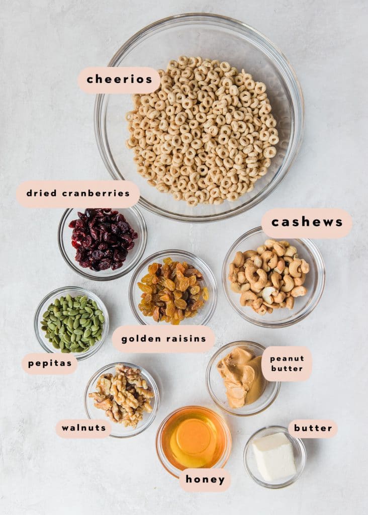 ingredients to make homemade Cheerio trail mix in small glass bowls 
