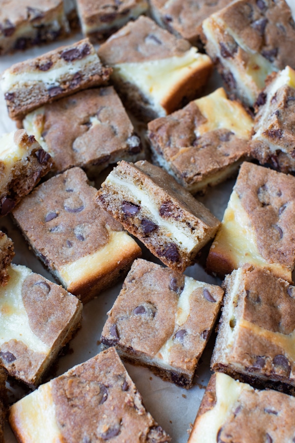 cheesecake cookie bars cut into squares on parchment paper 
