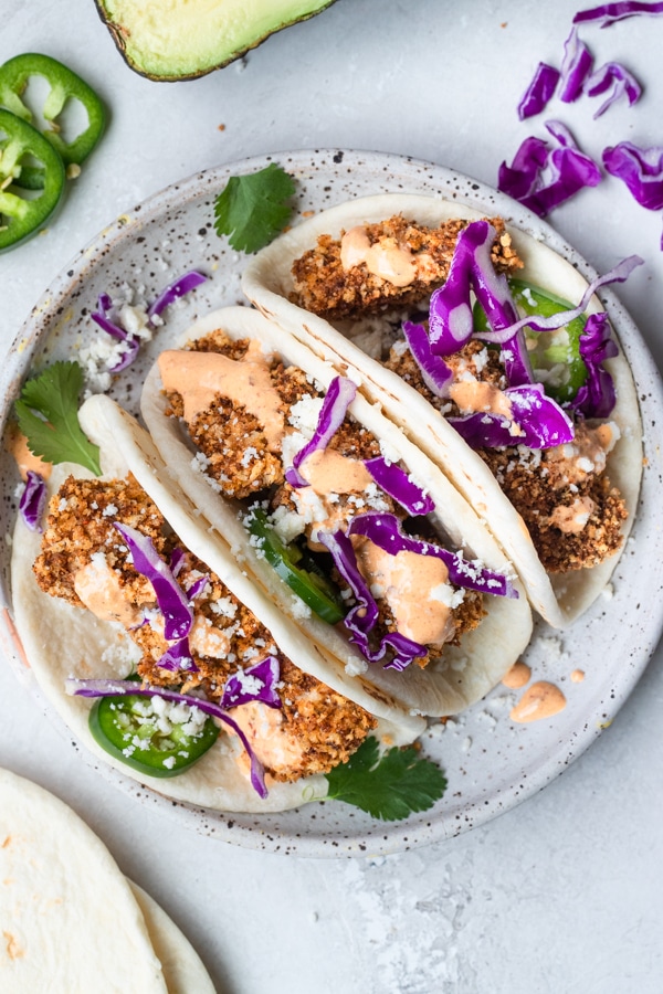 mahi mahi tacos on a white speckled plate