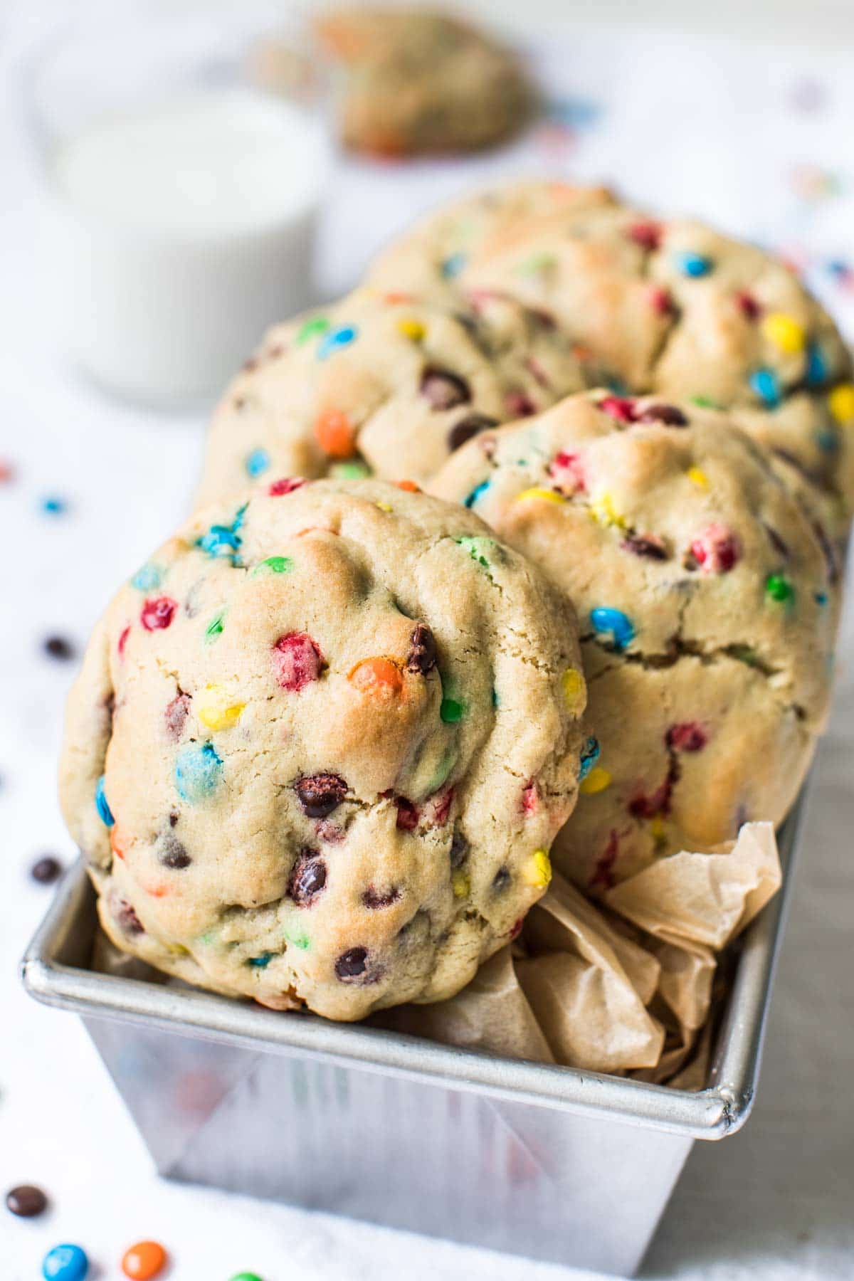 m&m cookies made with chocolate chips in a tin with parchment paper