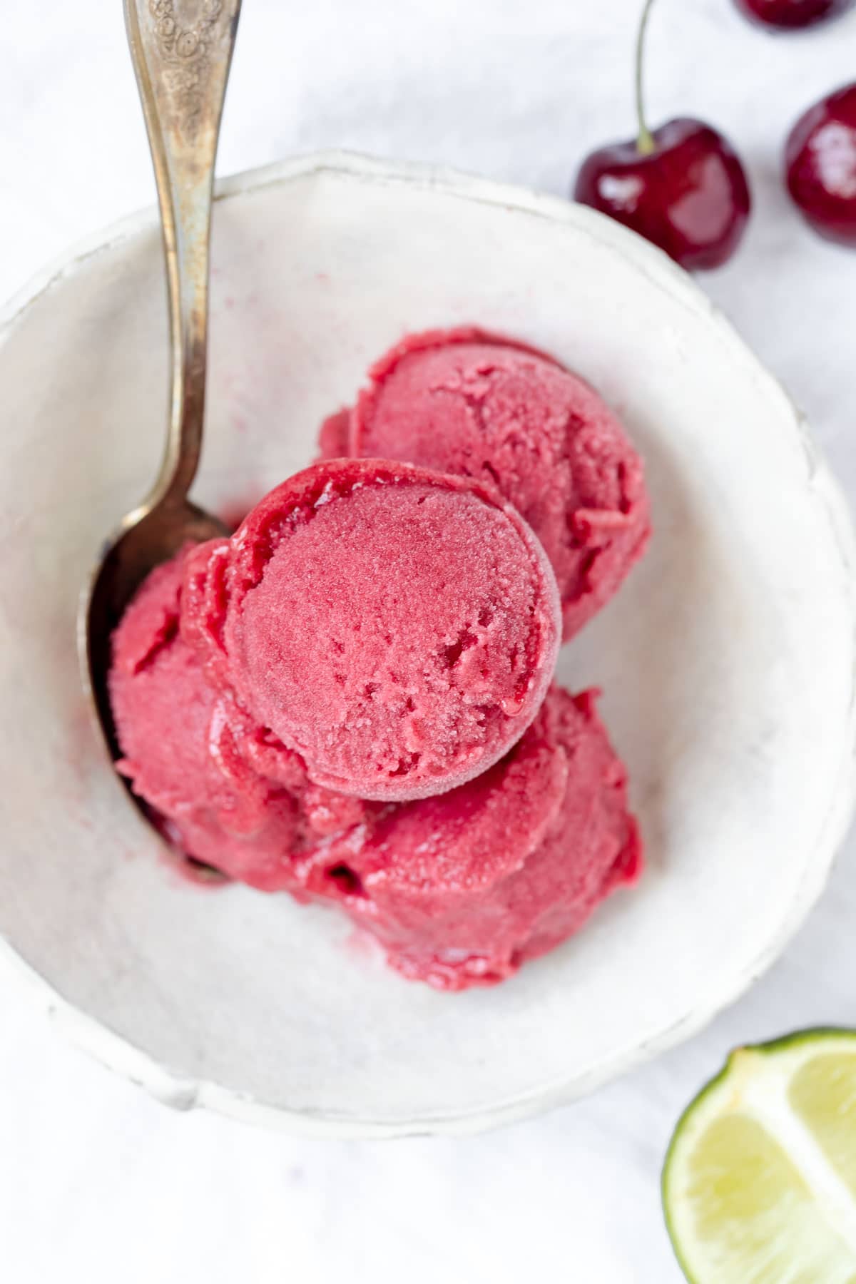 4 scoops of sorbet in a white bowl with a spoon 