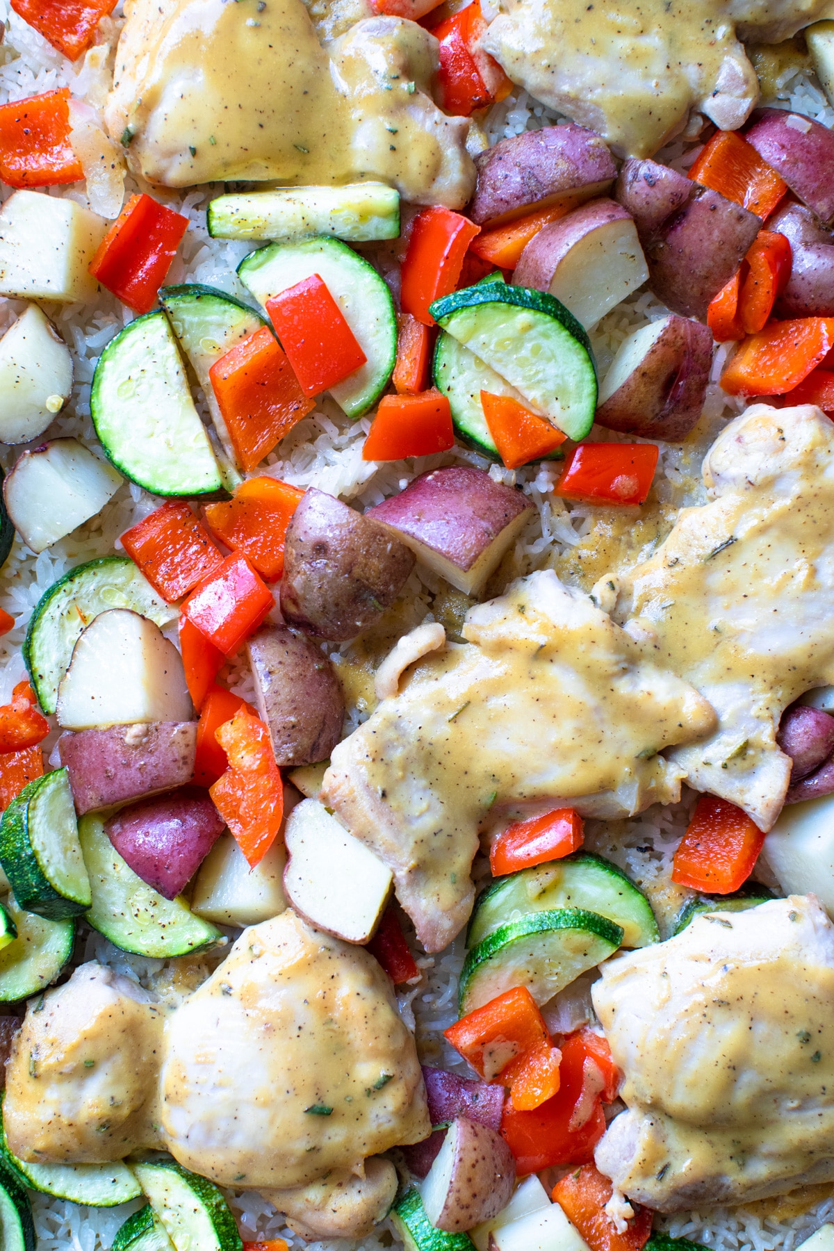 chicken thighs on a sheet pan with veggies and rice