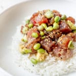 ahi tuna poke on top of white rice in a white bowl