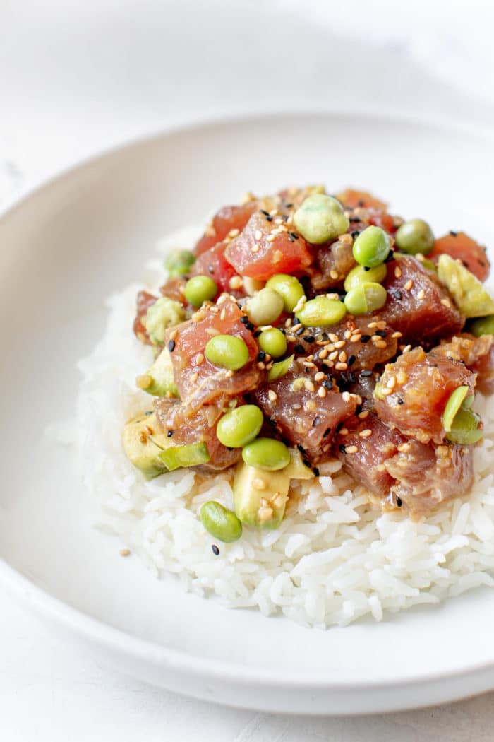 ahi tuna poke on top of white rice in a white bowl