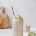 smoothie in a glass topped with diced kiwi