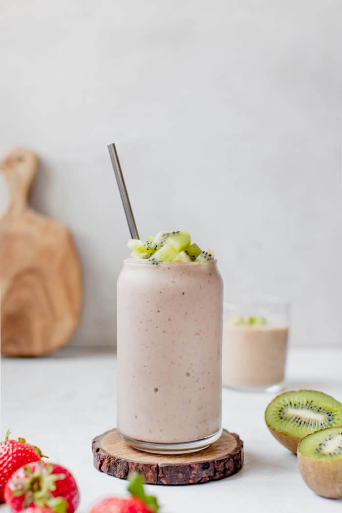 smoothie in a glass topped with diced kiwi