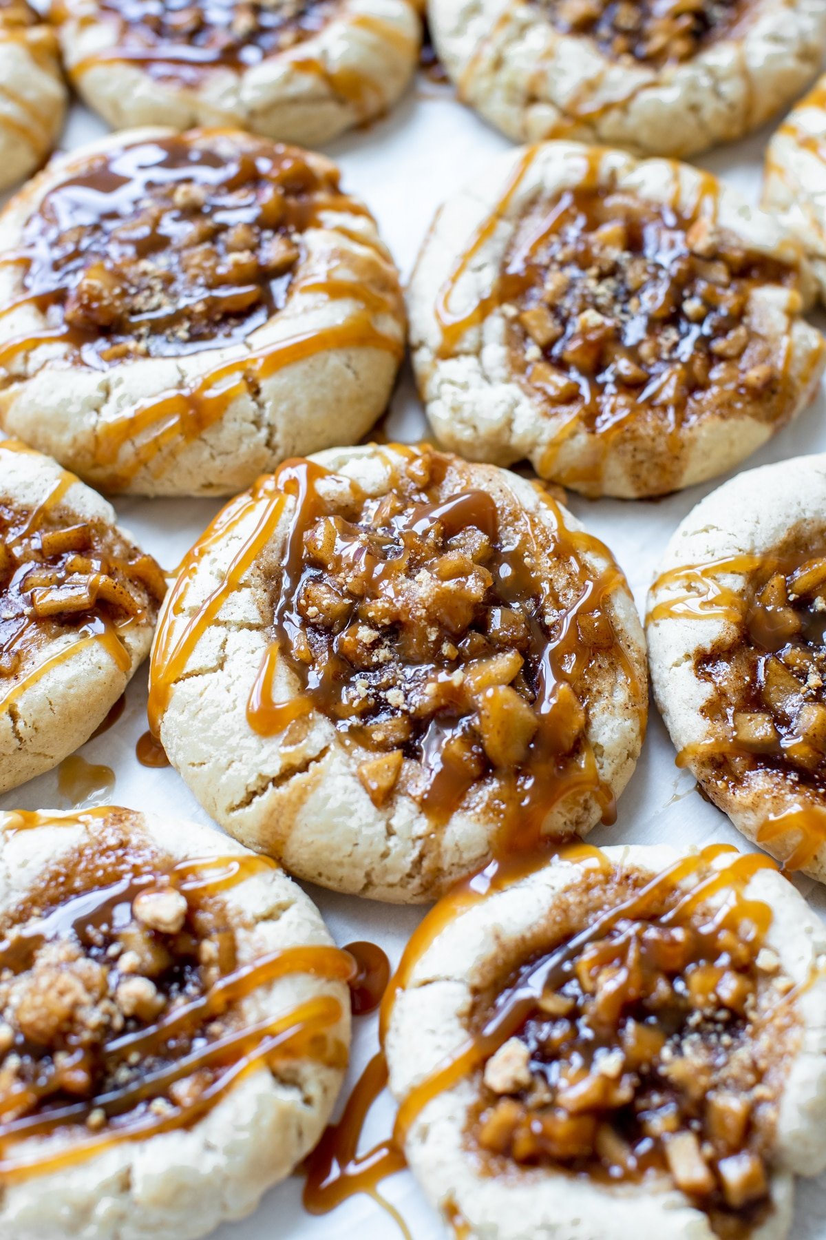 sugar cookies with an apple pie filling in the center with a caramel drizzle on top