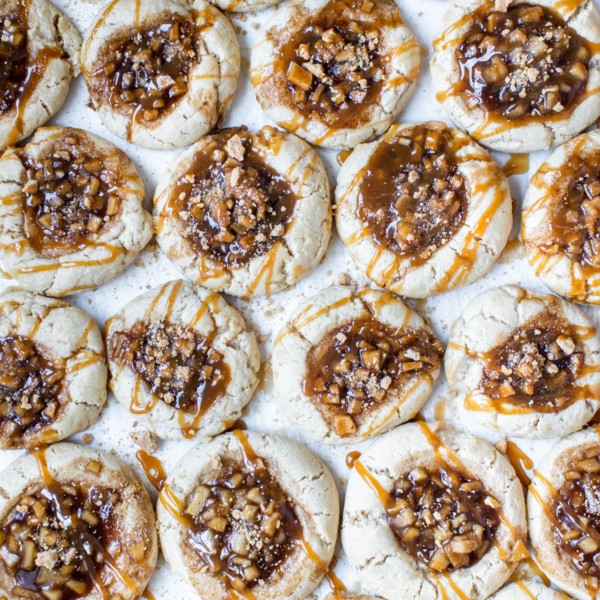 sugar cookies with an apple pie filling in the center with a caramel drizzle on top