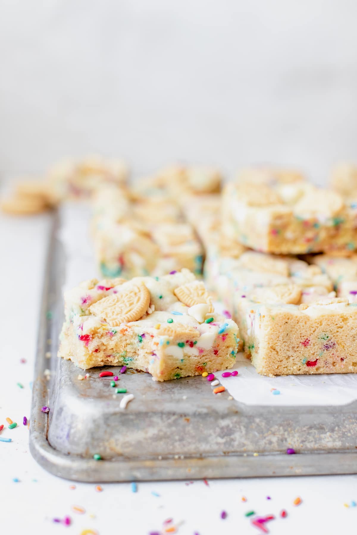funfetti cookie bar on a cookie sheet lined with parchment paper