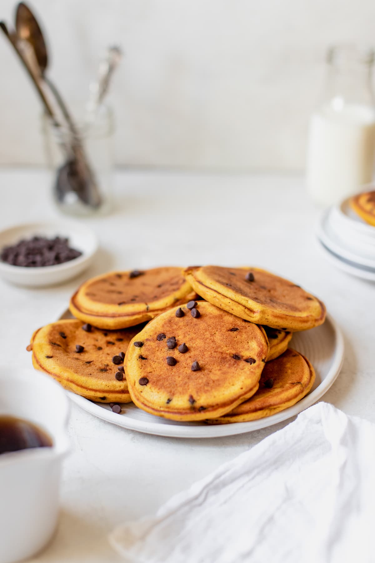 pumpkin pancakes on a white plate with chocolate chips on top