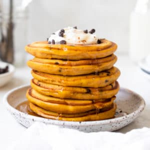 syrup being poured on chocolate chip pumpkin pancakes