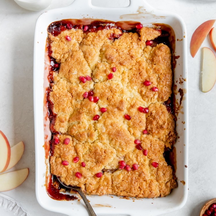cobbler in a baking dish topped with pomegranate seeds
