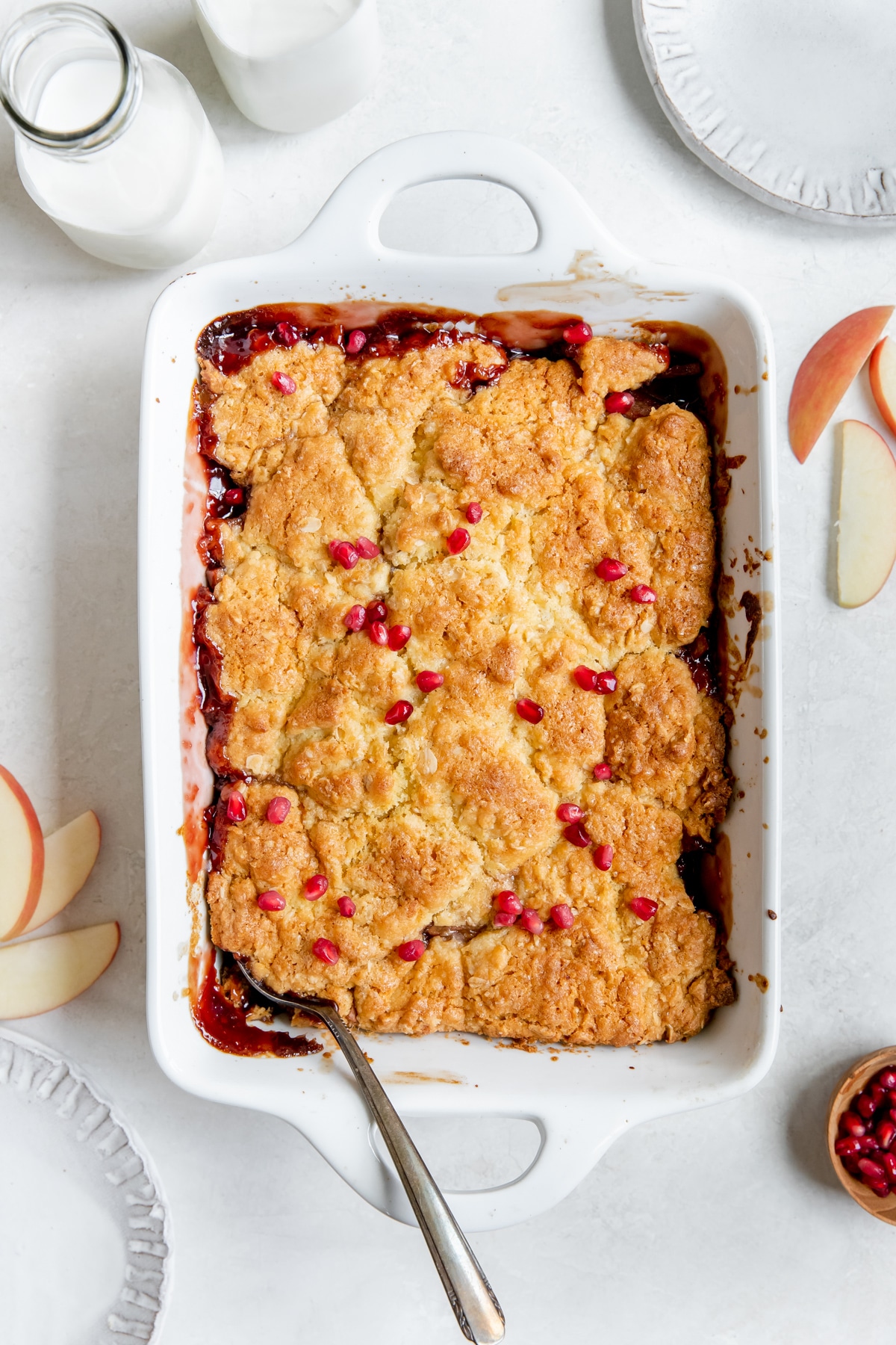 cobbler in a white baking dish topped with pomegranate seeds